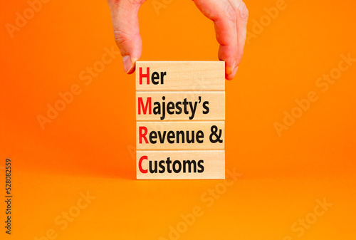 HMRC her majestys revenue and customs symbol. Concept words HMRC her majestys revenue and customs on blocks on beautiful orange background. Business HMRC revenue and customs concept. Copy space. photo