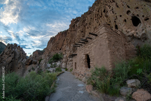 This ancestral Pueblo stone  structure at the bottom of a cliff was reconstructed during the 1920, wooden vigas support the roof,  Talus House, Bandelier NM photo