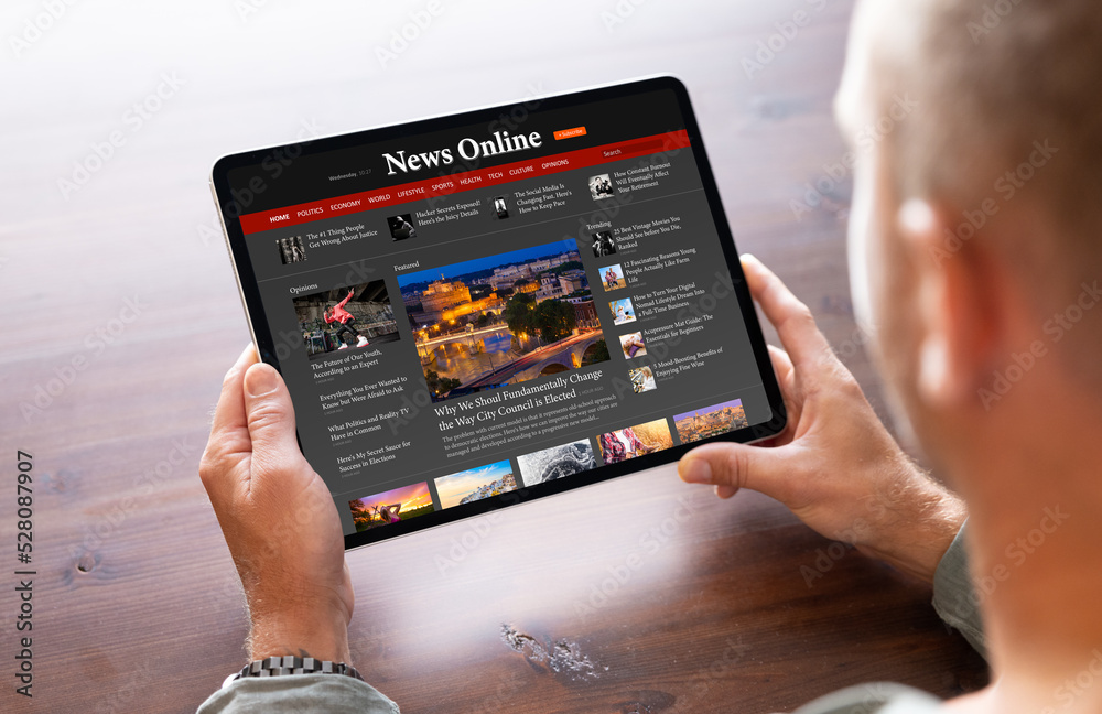 © Kaspars Grinvalds - Man reading news on tablet computer