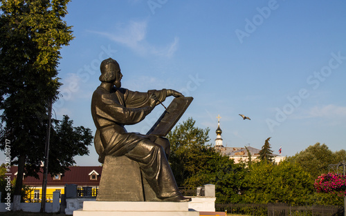 VLADIMIR, Russia - AUGUST, 17, 2022: Monument to the famous Russian icon painter Andrei Rublev by Oleg Komov in the old town among green trees on a sunny day photo