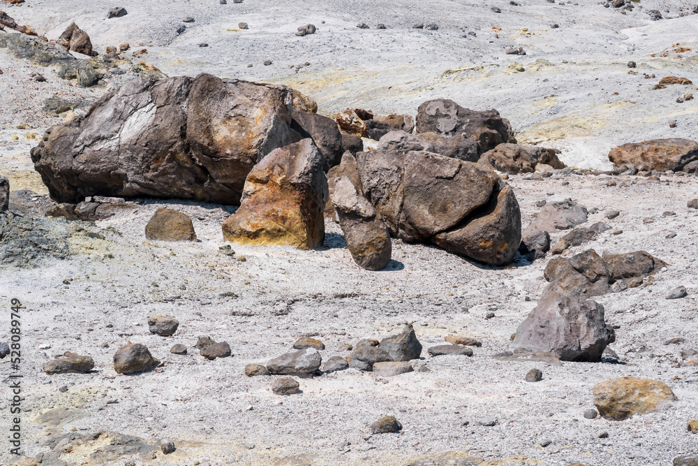 volcanic bombs among the tephra in a fumarole field on the slope of a volcano volcanic bombs among the tephra in a fumarole field on the slope of a volcano