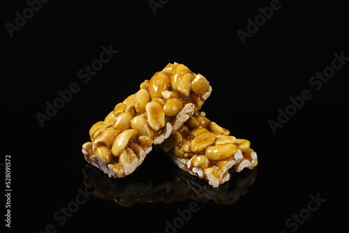 Pistachio kozinak on a black table with reflection. Close-up photo