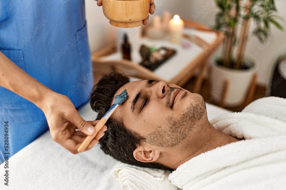 Man reciving facial treatment at beauty center. Man reciving facial treatment at beauty center.