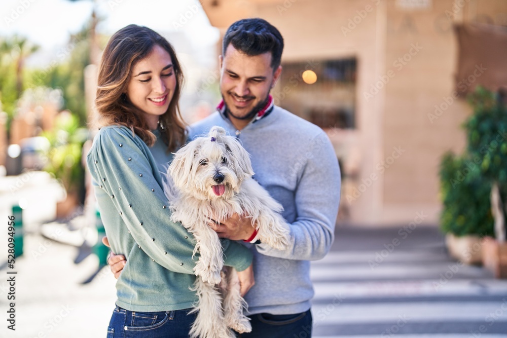 Man and woman holding dog hugging each other at street Man and woman holding dog hugging each other at street