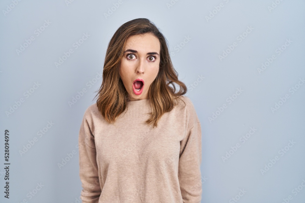 Young woman standing over isolated background afraid and shocked with surprise and amazed expression, fear and excited face. Young woman standing over isolated background afraid and shocked with surprise and amazed expression, fear and excited face.