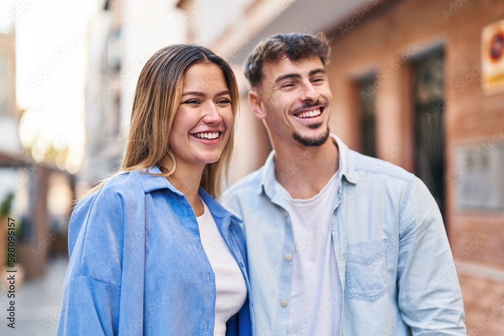 Young man and woman couple hugging each other standing at street Young man and woman couple hugging each other standing at street
