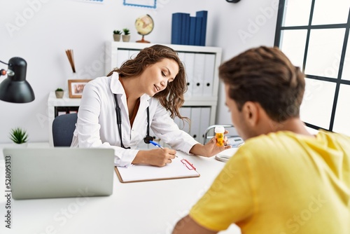 Man and woman having doctor visit prescribing pills at clinic