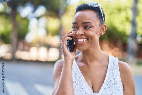 African american woman smiling confident talking on the smartphone at street