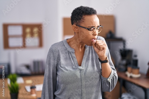 African american woman working at the office wearing glasses feeling unwell and coughing as symptom for cold or bronchitis. health care concept.