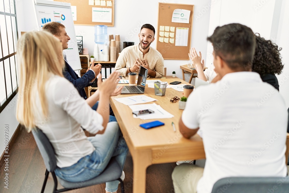 Group of young business workers smiling and clapping to partner at the office. Group of young business workers smiling and clapping to partner at the office.