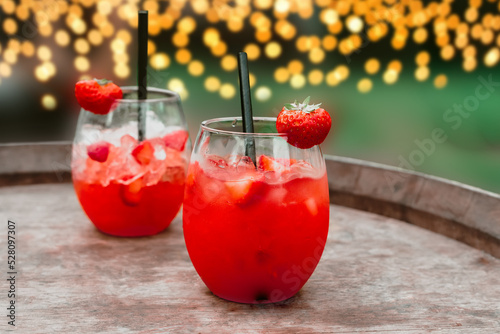 Red strawberry daiquiri cocktail or mocktail in glass with drinking straw. Refreshing summer drink for party or festive. photo