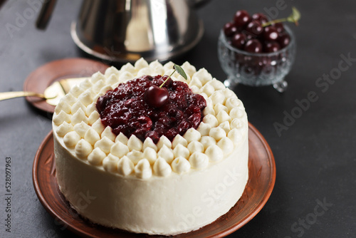 Biscuit cake, cherry souffle with cream cheese and cherry confiture on a black background. close-up