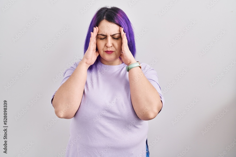 Plus size woman wit purple hair standing over isolated background with hand on head for pain in head because stress. suffering migraine. Plus size woman wit purple hair standing over isolated background with hand on head for pain in head because stress. suffering migraine.