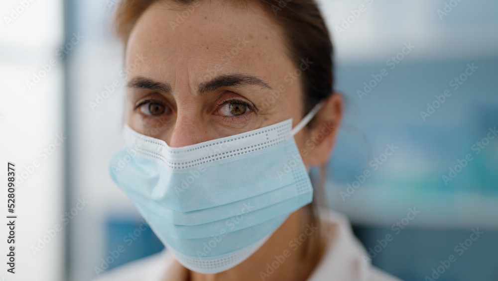 Middle age hispanic woman wearing scientist uniform and medical mask at laboratory Middle age hispanic woman wearing scientist uniform and medical mask at laboratory