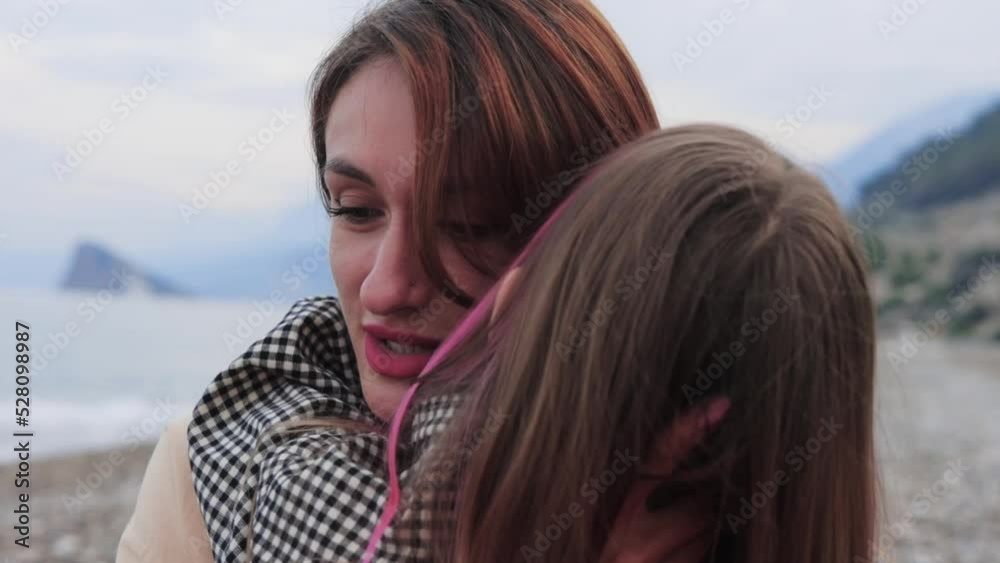 Mother hugging with her little daughter by the sea Mother hugging with her little daughter by the sea