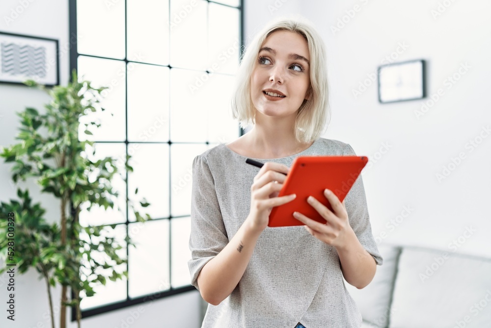 Young caucasian woman smiling confident using touchpad at home Young caucasian woman smiling confident using touchpad at home