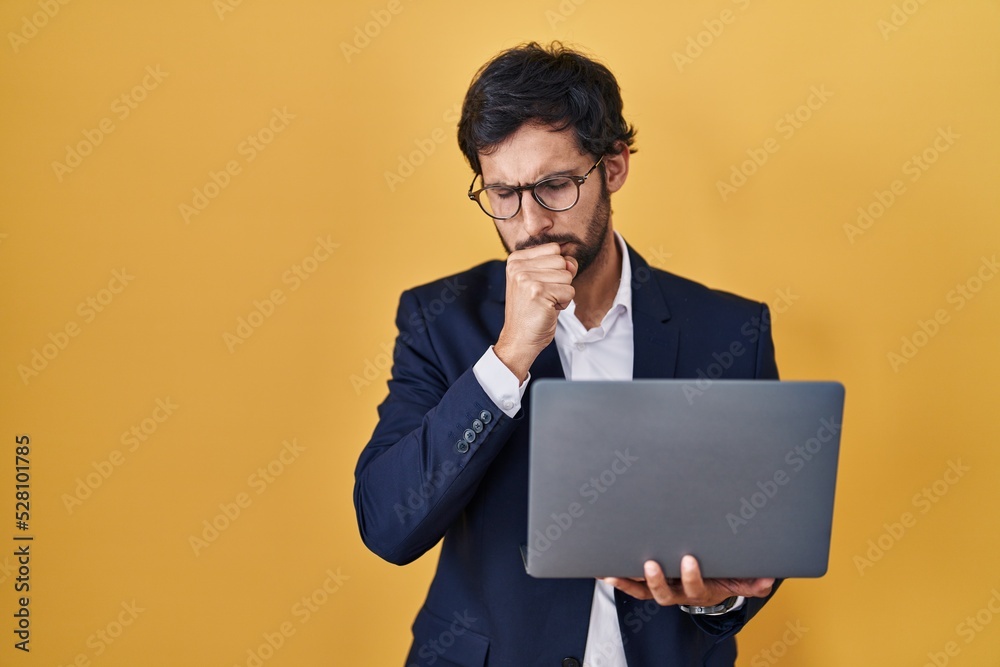 Handsome latin man working using computer laptop feeling unwell and coughing as symptom for cold or bronchitis. health care concept. Handsome latin man working using computer laptop feeling unwell and coughing as symptom for cold or bronchitis. health care concept.