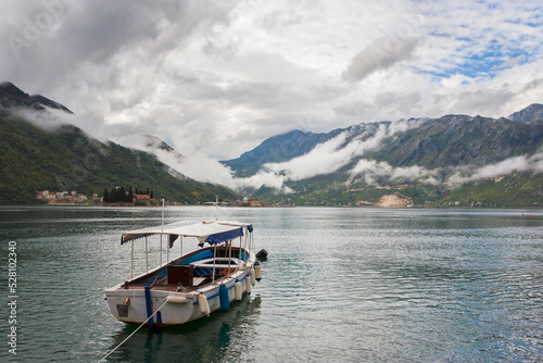 The Bay of Kotor (Boka Kotorska) from the little town of Perast, Montenegro, on a cloudy day, with a motor launch moored in the foreground