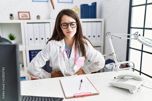 Young doctor woman wearing doctor uniform and stethoscope at the clinic with hand on stomach because indigestion  painful illness feeling unwell. ache concept.
