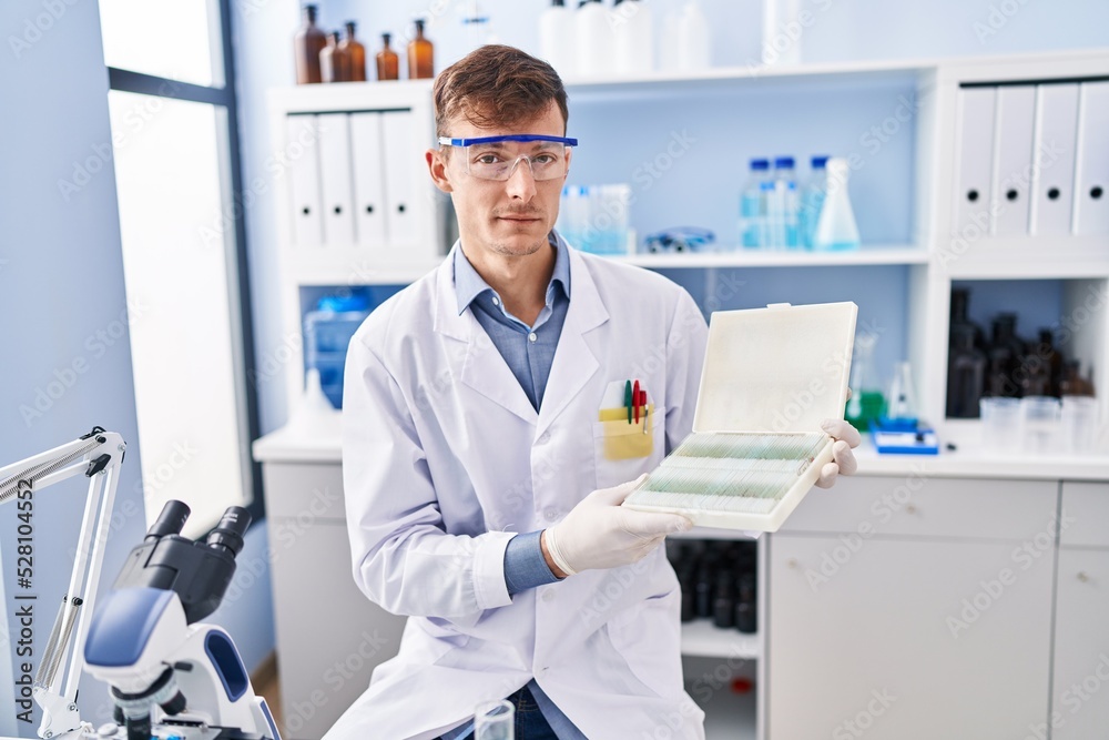 Caucasian man working at scientist laboratory relaxed with serious expression on face. simple and natural looking at the camera. Caucasian man working at scientist laboratory relaxed with serious expression on face. simple and natural looking at the camera.