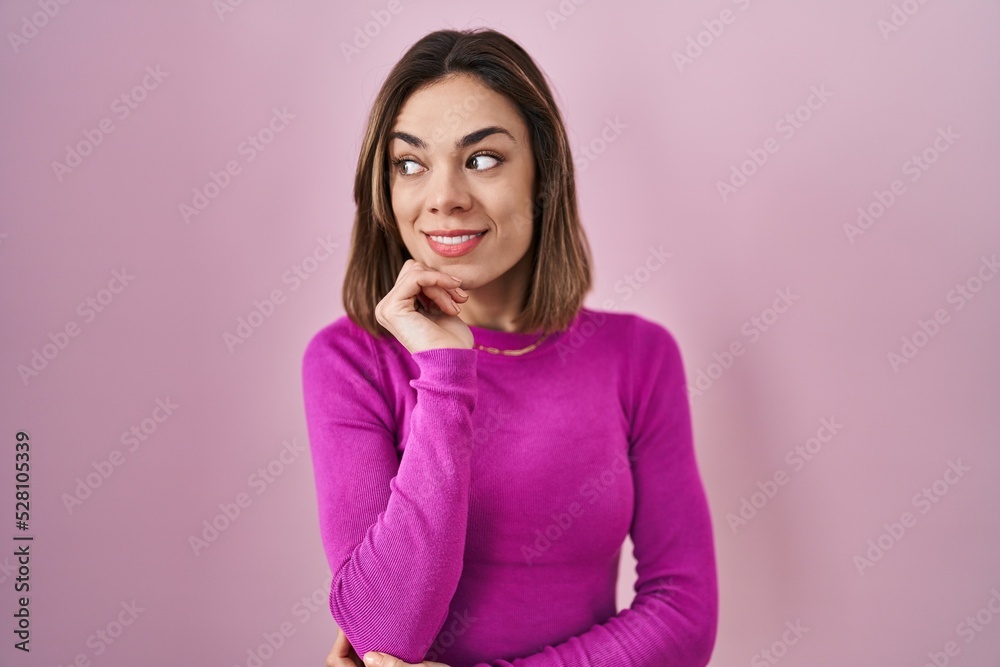 Hispanic woman standing over pink background with hand on chin thinking about question, pensive expression. smiling and thoughtful face. doubt concept. Hispanic woman standing over pink background with hand on chin thinking about question, pensive expression. smiling and thoughtful face. doubt concept.