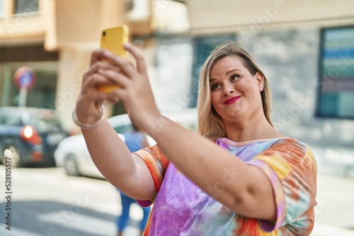 Young woman smiling confident making selfie by the smartphone at street