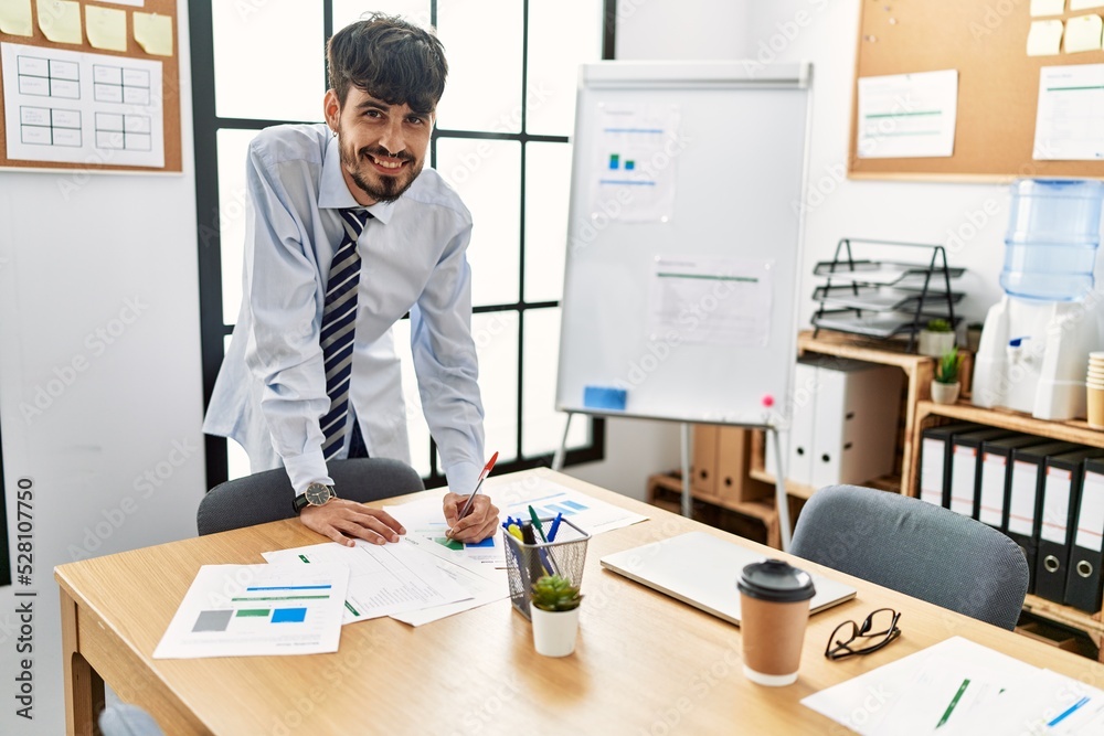Young hispanic businessman smiling happy working at the office. Young hispanic businessman smiling happy working at the office.