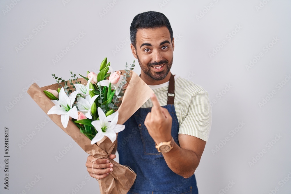 Hispanic man with beard working as florist beckoning come here gesture with hand inviting welcoming happy and smiling Hispanic man with beard working as florist beckoning come here gesture with hand inviting welcoming happy and smiling