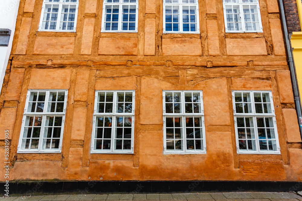 Facade of an old orange colored building with windows in Helsingor, Zealand, Denmark, Europe