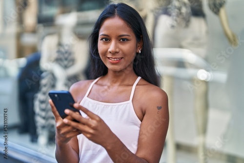 Young beautiful woman smiling confident using smartphone at street