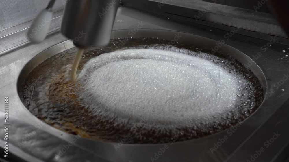 Churrero friendo roscas de churros en una cocina de una chocolatería. Madrid, España, septiembre de 2022. Churrero friendo roscas de churros en una cocina de una chocolatería. Madrid, España, septiembre de 2022.