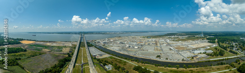 Aerial view of the Delaware Memorial Bridge spanning across the Delaware river connecting to the New Jersey turnpike with a giant chemical plan in the background