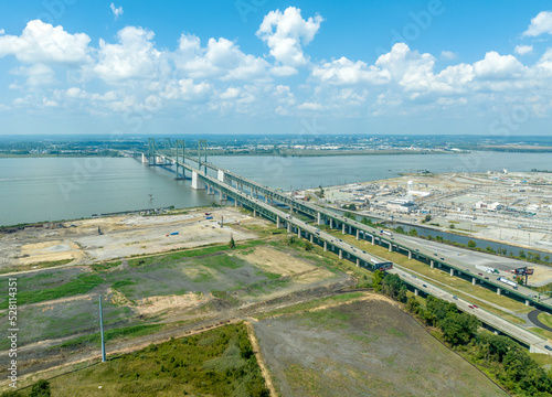 Aerial view of the Delaware Memorial Bridge spanning across the Delaware river connecting to the New Jersey turnpike with a giant chemical plan in the background