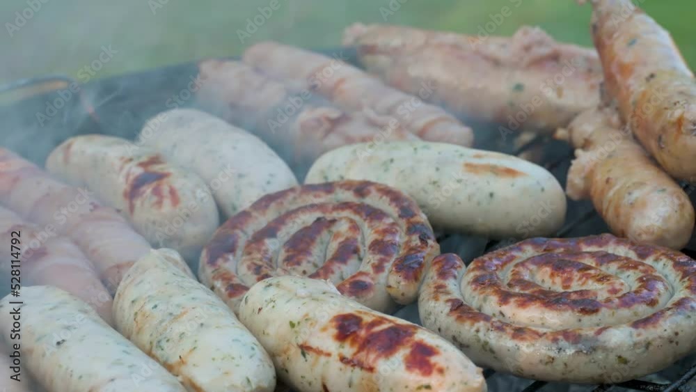 Man grilling and rotating meat sausages. 4k video footage Man grilling and rotating meat sausages. 4k video footage