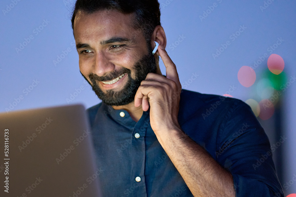 Smiling indian business man wearing earbud having virtual meeting ...