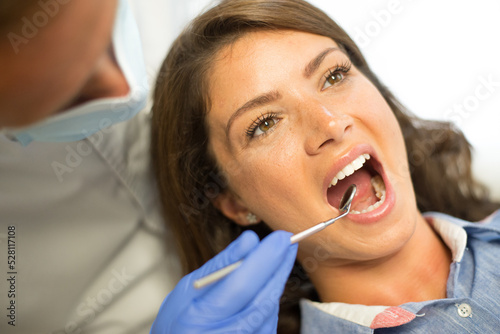 Young woman checking her teeth at the dentist clinic