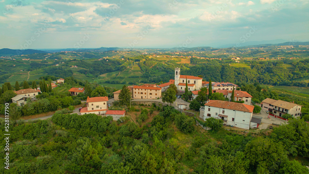 AERIAL: Picturesque settlement on top of small hill in embrace of wine country