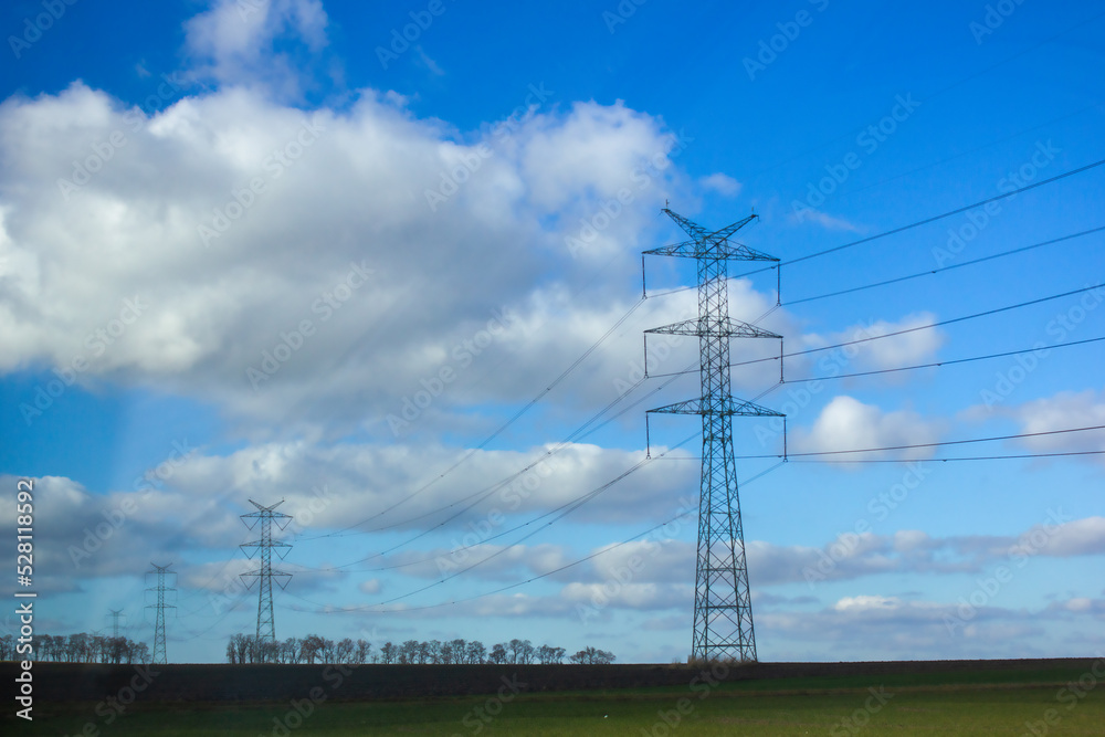 Power transmission lines in the field. High voltage power transmission towers