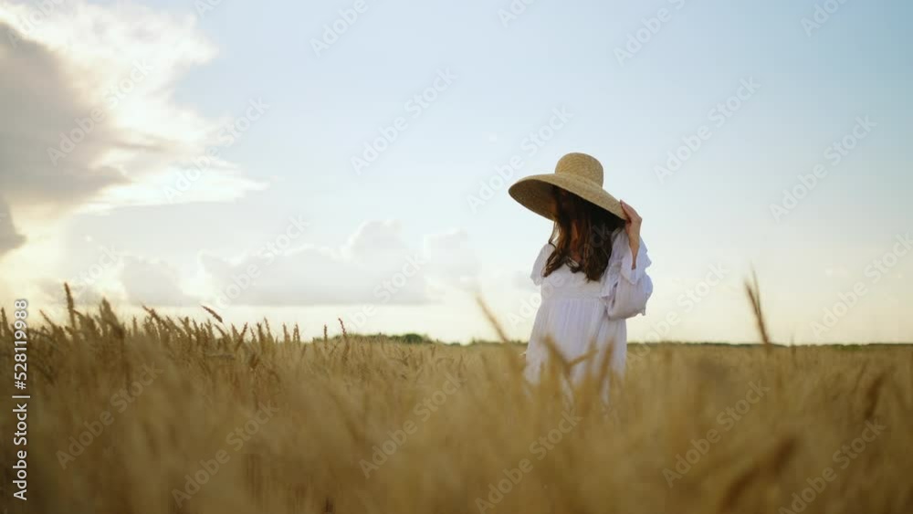 calm beautiful woman is walking alone on golden rye field in summer day, portrait of pretty lady