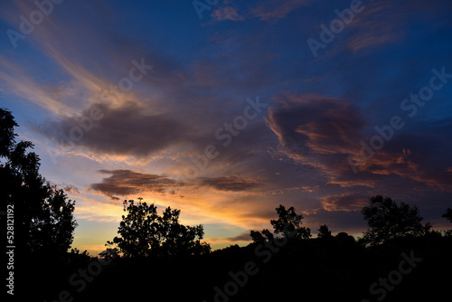 dramatic morning sky with clouds and some trees