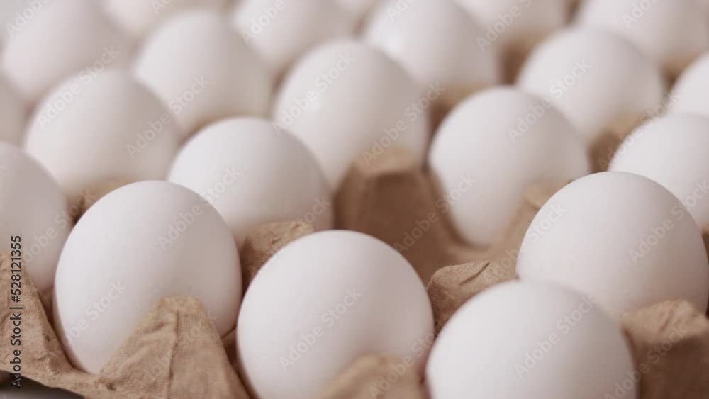 White chicken eggs in a cardboard box. Fresh raw eggs in a paper egg container for store and shop. egg tray with eggs on white table background. Top view. preparation to easter holiday. White chicken eggs in a cardboard box. Fresh raw eggs in a paper egg container for store and shop. egg tray with eggs on white table background. Top view. preparation to easter holiday.