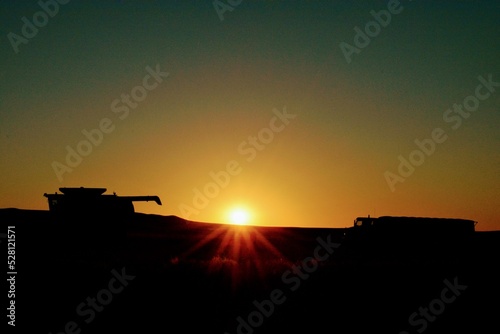 Silhouette of a Grain Combine against a Brilliant Montana Sunset