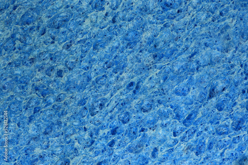 Extreme close-up of a dry blue kitchen dishwashing sponge flat straight on