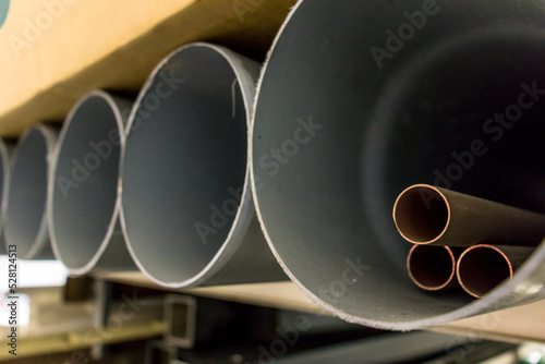Plastic and copper plumbing pipes, on a shelf.