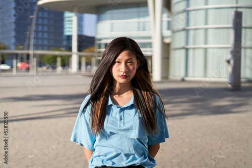 Serious asian Student. Chinese girl looking at the camera outdoors on campus of university. Ethnicity people.