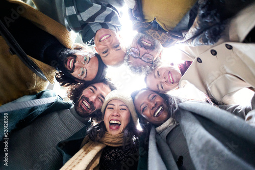 Low angle circle of a cheerful diverse group of people of diverse races an aged looking at camera happy together having fun © CarlosBarquero