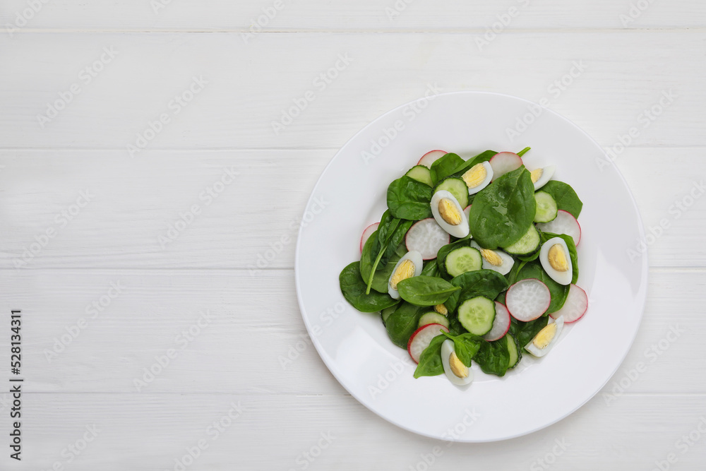 Delicious salad with boiled eggs, radish and spinach on white wooden table, top view. Space for text