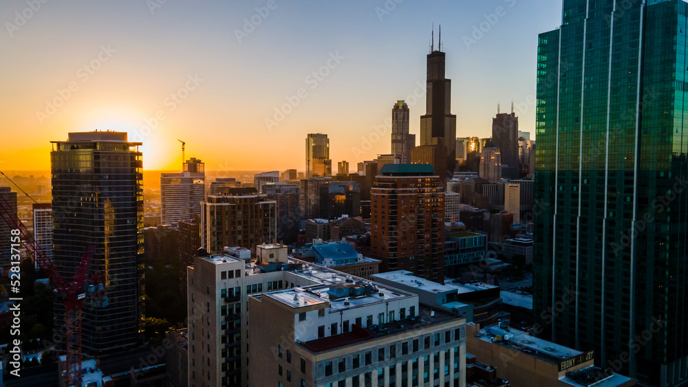 Fototapeta premium Chicago, IL USA September 1 2022: establishing aerial drone footage of Chicago downtown during sunset on a mid summer evening. the contemporary buildings are beautiful to watch for tourist 