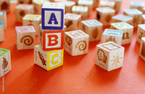 Wooden multicolored blocks with letters on orange background. Education for preschooler, reading, alphabet. Back to school concept