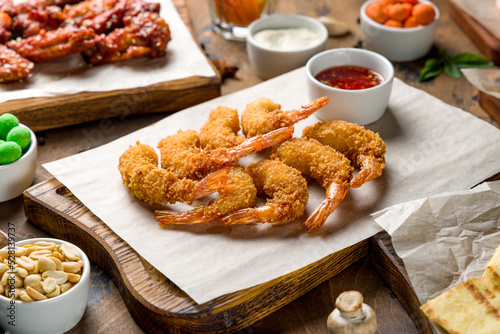 fried tempura shrimps on the board with sweet chili sauce on wooden table photo